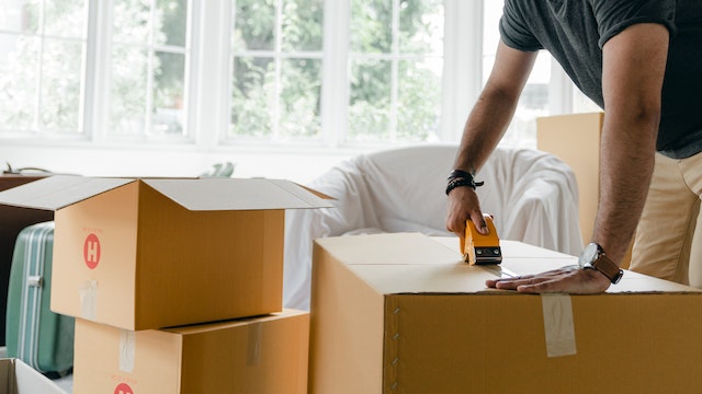 man packing moving boxes